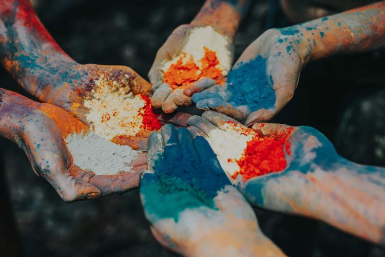 Three Pairs of Hands Holding and Stained with Powdered Dyes in Blue, Green, Orange, Red, White Colors